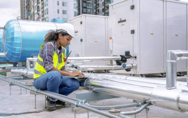 Technician inspects and controls the cooling system of a large factory air conditioner